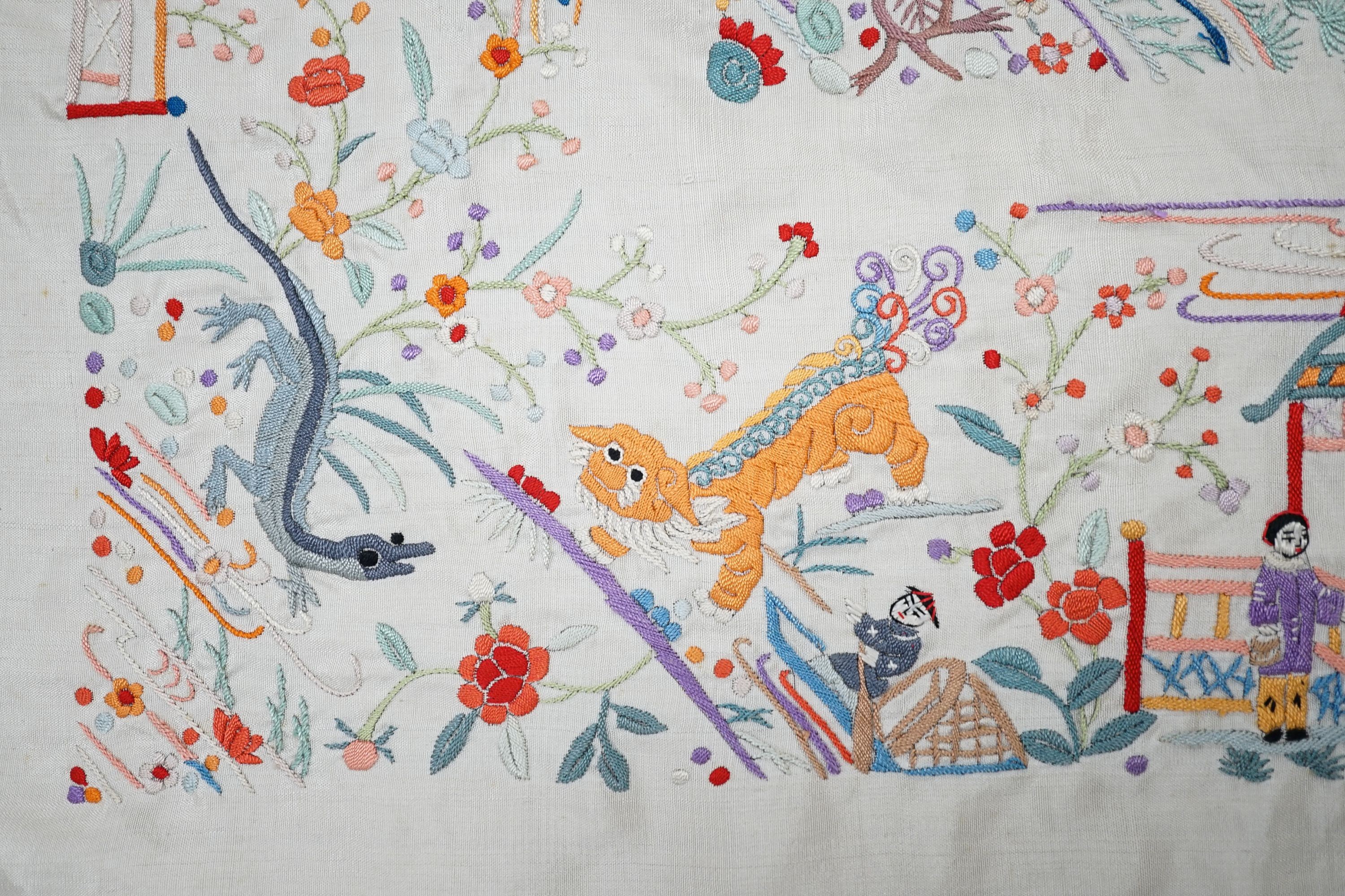 A Chinese cream silk shawl with fine multi coloured all over embroidery depicting figurative scenes and animals